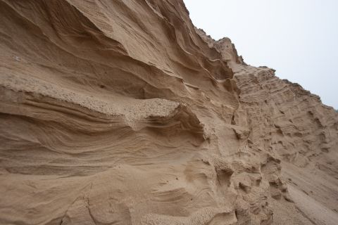 1993 Ford Bronco - The image shows a close-up view of a sandy cliff face with distinct horizontal striations and erosion patterns. The texture of the sand is…