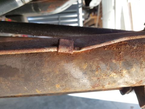 1978 Ford Bronco - A close-up view of a corroded metal frame, showing details of its construction.