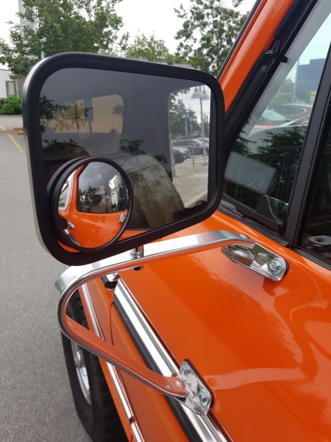 1978 Ford Bronco - Close-up of the side mirror and fender of an orange 1978 Ford Bronco.