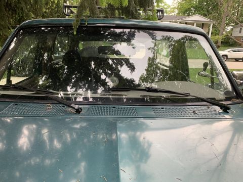 1996 Ford Bronco - Front view of a green 1996 Ford Bronco, showing the windshield, hood, and roof rack.