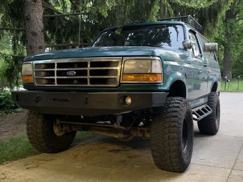 1996 Ford Bronco - This 1996 Ford Bronco features an aftermarket bumper and roof rack, seen from a three-quarter front view.