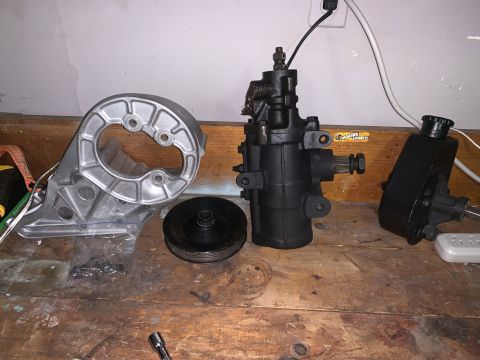 1996 Ford Bronco - Various automotive steering system parts are laid out on a workbench.