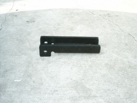 1984 Ford Bronco - A black metal bracket with two holes and a cutout is shown against a concrete surface. The registry label indicates it is a SAS part for a…