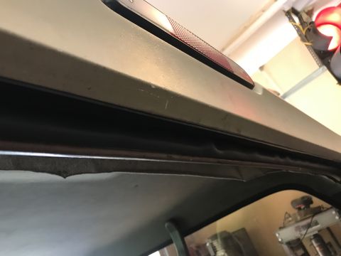 1994 Ford Bronco - Interior view of a vehicle's upper trim and headliner, with a brake light visible.