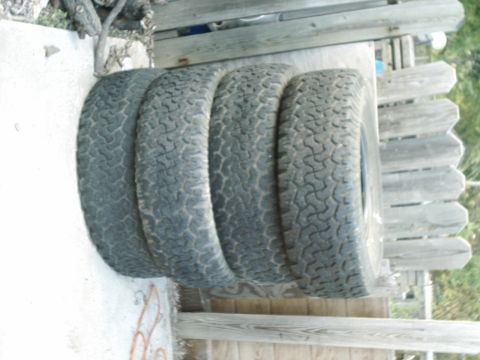 1984 Ford Bronco - A set of four off-road tires are visible, likely for sale.