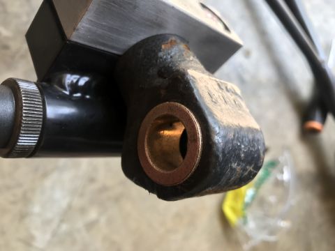 1994 Ford Bronco - A close-up view of a black tailgate hinge component a brass bushing.