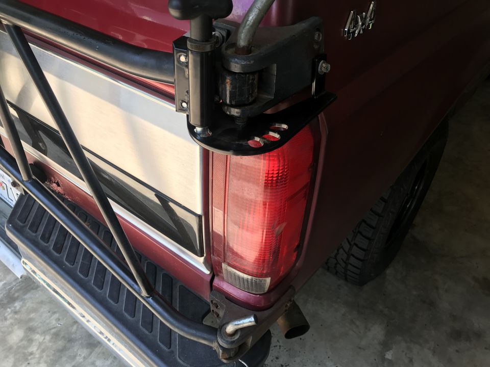 1994 Ford Bronco rear bumper with tire carrier mounted. Red paint and chrome trim visible