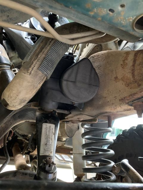 1996 Ford Bronco - Underside view of a vehicle's steering mechanism and coil spring assembly.
