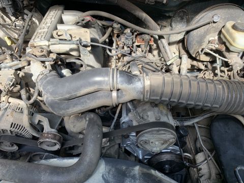 1996 Ford Bronco - Close-up view of a vehicle's engine compartment, showing various mechanical parts and wiring.