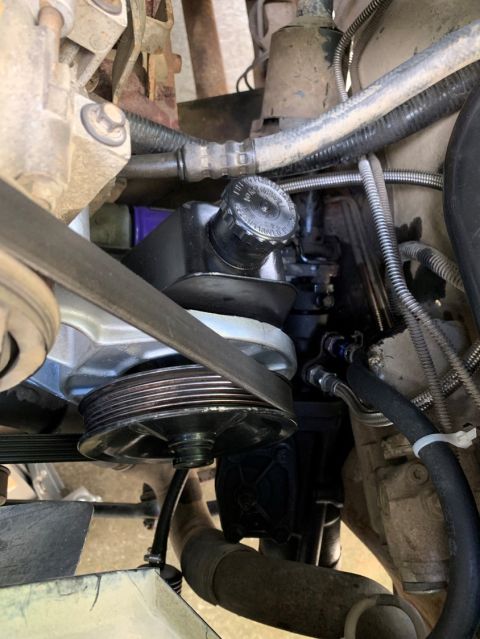 1996 Ford Bronco - Close-up view of the power steering pump and pulley assembly within an engine bay.