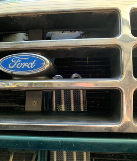 1996 Ford Bronco - Close-up of the front grille on a 1996 Ford Bronco, showing the Ford emblem and radiator.