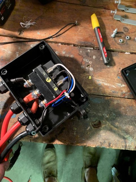 1996 Ford Bronco - An electrical component box with various wires and a yellow marker on a workbench.