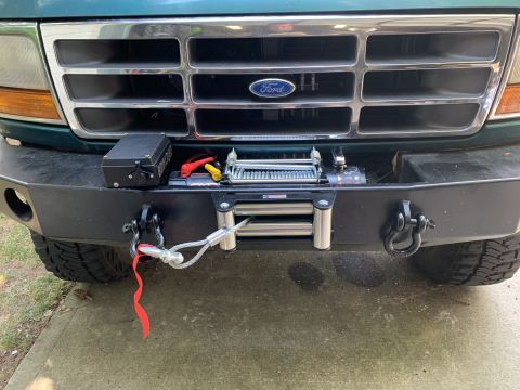 1996 Ford Bronco - This Ford truck features a custom bumper with a winch and tow hooks, along with a prominent Ford emblem on the grille.