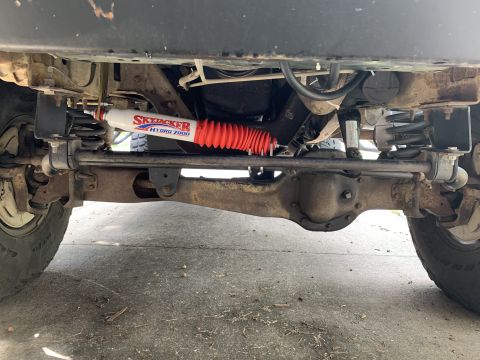 1996 Ford Bronco - Close-up view of the front suspension and steering components of an off-road vehicle.