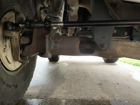 1996 Ford Bronco - Close-up view of the front suspension and steering linkage of an older vehicle.
