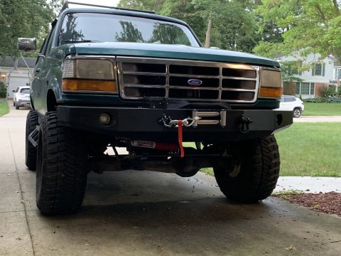 1996 Ford Bronco - This 1996 Ford Bronco features a prominent aftermarket bumper with a winch, and a grille consistent with that model year.
