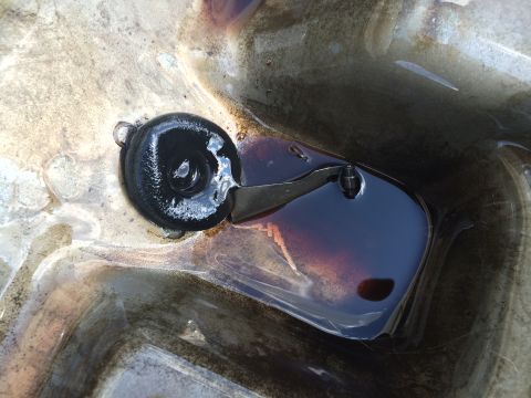 1993 Ford Bronco - Close-up of an oil pan and drain plug, showing the fluid level.