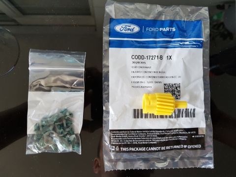 1978 Ford Bronco - A yellow gear and a bag of green clips are shown next to a Ford Parts package.