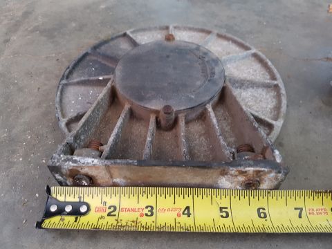 1978 Ford Bronco - A close-up shot shows a metal automotive part, possibly a differential housing, with a yellow measuring tape placed in front of it. The par…