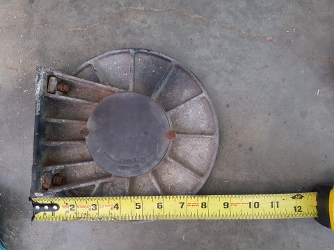 1978 Ford Bronco - A metal component, possibly a pulley or winch part, is shown with a yellow measuring tape indicating its size. The part has a circular sect…