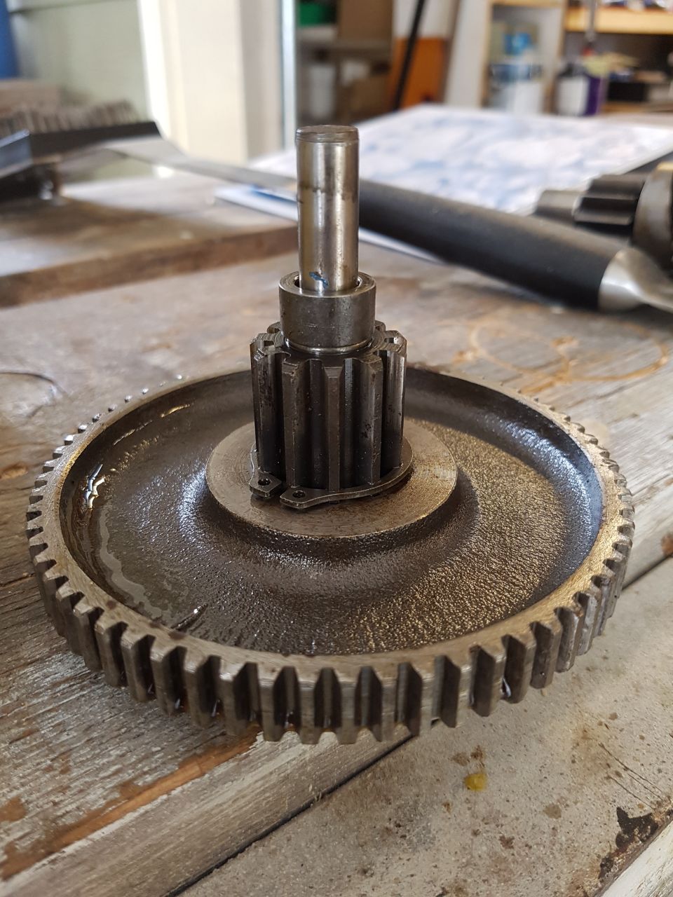 Metal gear assembly with shaft on a wooden surface.