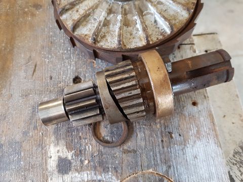 1978 Ford Bronco - A close-up view shows a disassembled metal shaft with gears and a bronze bushing, resting on a weathered wooden surface. In the background,…