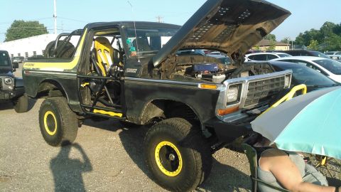1978 Ford Bronco - This modified 1978 Ford Bronco features a roll cage, racing seats, and off-road tires, with its hood raised to reveal the engine.