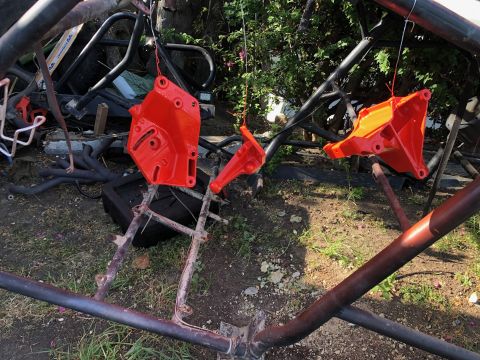 1992 Jeep Wrangler - Several engine components are suspended and freshly painted bright orange, set against an outdoor backdrop.