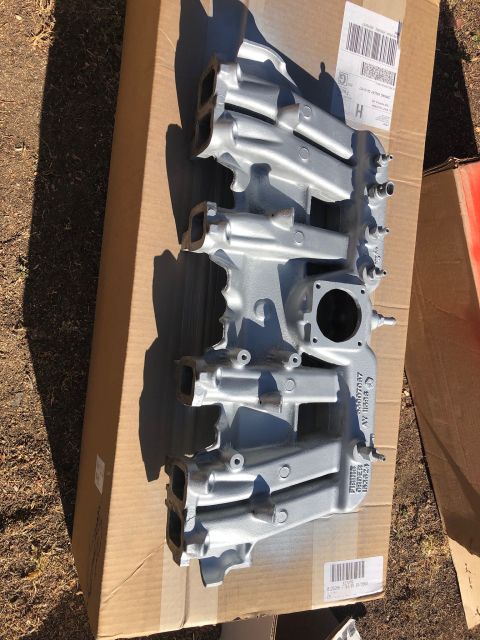 1992 Jeep Wrangler - Intake manifold with visible part numbers and text sits on a cardboard box outdoors.