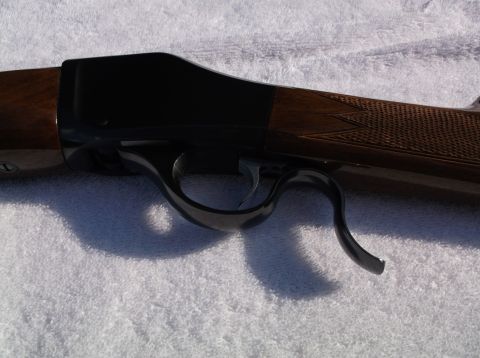 1995 Mercury Grand Marquis - Close-up view of the receiver and trigger assembly of a Browning shotgun, highlighting the wood grain and blued metal finish.
