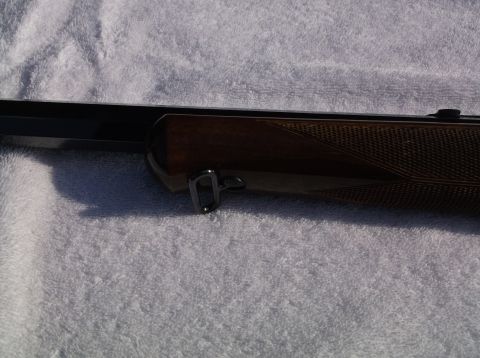1995 Mercury Grand Marquis - A detailed view of a rifle's wooden stock and metallic components is shown against a textured background.