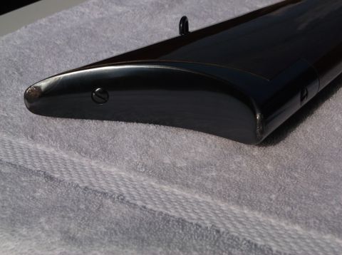 1995 Mercury Grand Marquis - Detail of a dark, glossy part with a visible screw, placed on a textured grey towel.