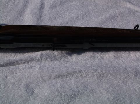 1995 Mercury Grand Marquis - Detail of a Browning shotgun receiver, showing the textured wood stock and metal components.
