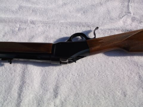 1995 Mercury Grand Marquis - Detail of a lever-action rifle, showing the trigger guard, lever, and checkered wooden stock.