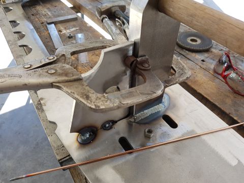 1978 Ford Bronco - Metal fabrication in progress, with clamps holding pieces for welding and a welding rod on the workbench.