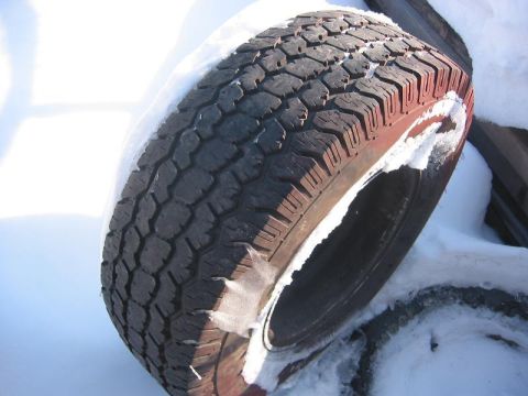 1985 Ford Bronco - A tire sits in the snow, its tread pattern clearly visible.