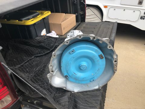 1992 Jeep Wrangler - Automatic transmission part resting on a quilted mat in the bed of a pickup truck.