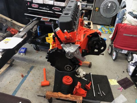1992 Jeep Wrangler - A freshly rebuilt engine sits on a stand in a garage, surrounded by tools and equipment.