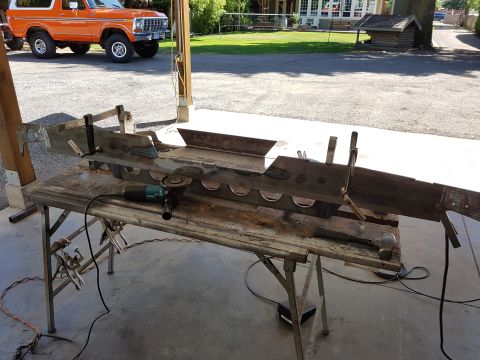 1978 Ford Bronco - Orange 1978 Ford Bronco in background, foreground shows metal fabrication project on a table.