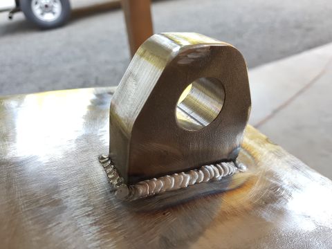 1978 Ford Bronco - A metal bracket, likely a tow hook or tie-down point, is shown after being welded to a surface. The Supermotors.net logo is visible in the…