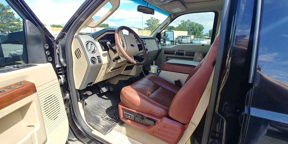 Truck interior with brown leather seats, wood trim, and a McDonald's cup on the console. The dashboard shows a Ford logo