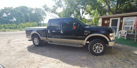 2010 Ford F-250 - This Ford F-250 Super Duty pickup truck is parked in front of a small building.