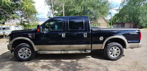 2010 Ford F-250 - This 2010 Ford F-250 crew cab pickup truck is shown from the side in a rural setting.