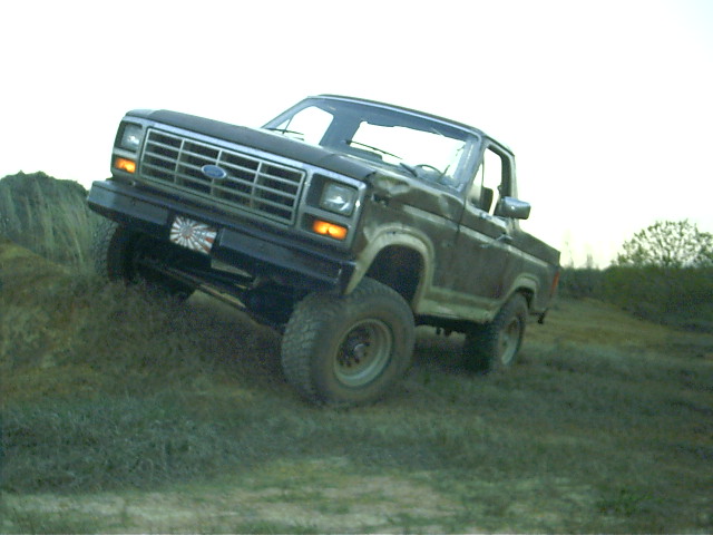 Ford F-Series truck driving up a grassy hill