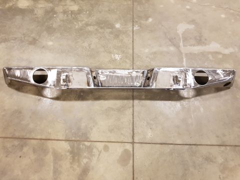 1978 Ford Bronco - This custom chrome rear bumper features cutouts for exhaust pipes and is shown on a concrete floor.