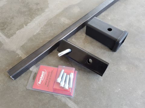 1978 Ford Bronco - Hitch receiver components and a stud kit are laid out on a concrete floor.