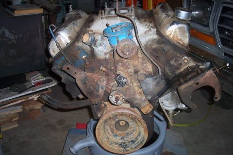 1978 Ford Bronco - A V8 engine, showing significant rust and wear, sits in a workshop environment.