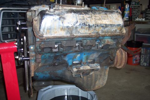 1978 Ford Bronco - This engine is mounted on a stand, ready for repair or rebuilding. The valve cover has some text on it.