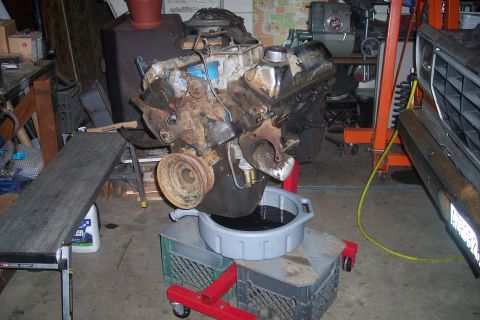 1978 Ford Bronco - An engine is being worked on in a garage, with a vehicle partially visible in the background.