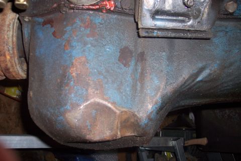 1978 Ford Bronco - This is a close-up view of a heavily rusted and worn engine oil pan, showing signs of age and use.